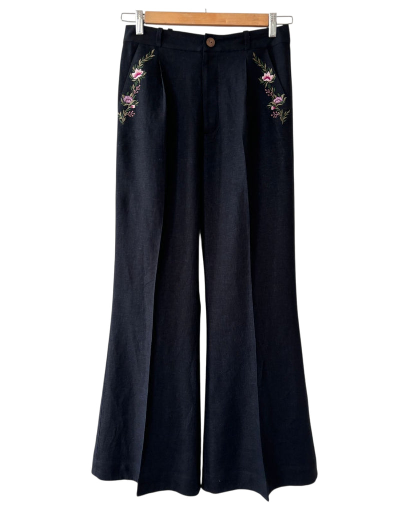 Close-up of floral embroidery on black linen trousers