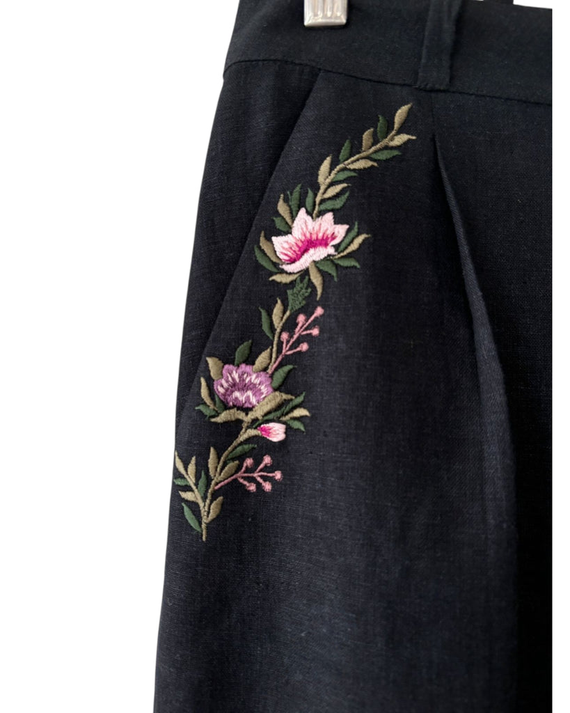 Close-up of floral embroidery on pockets on black linen trousers