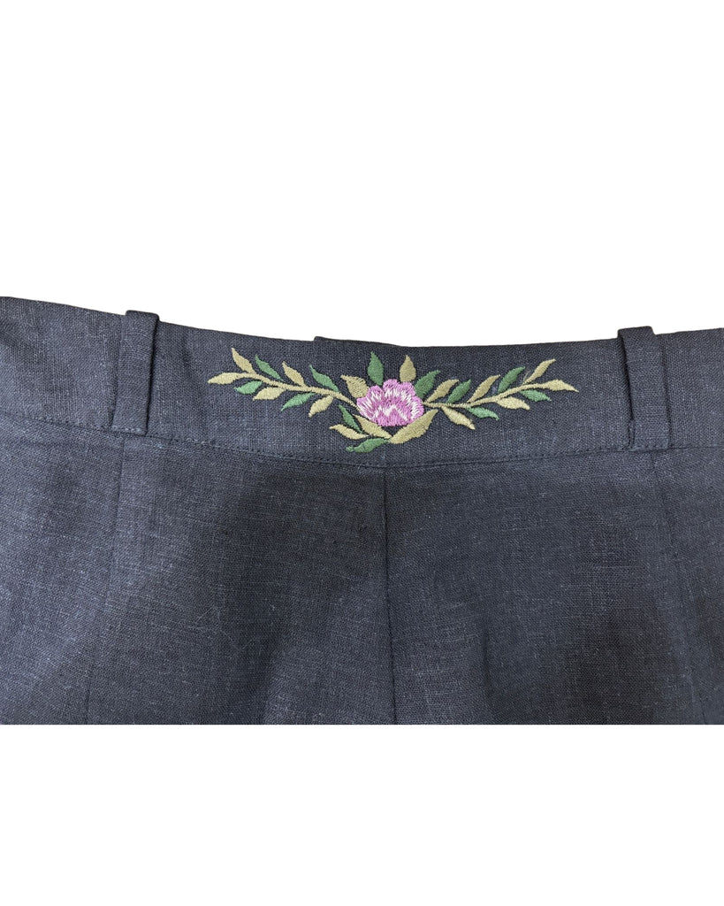 Close-up of waistband floral embroidery on black linen trousers