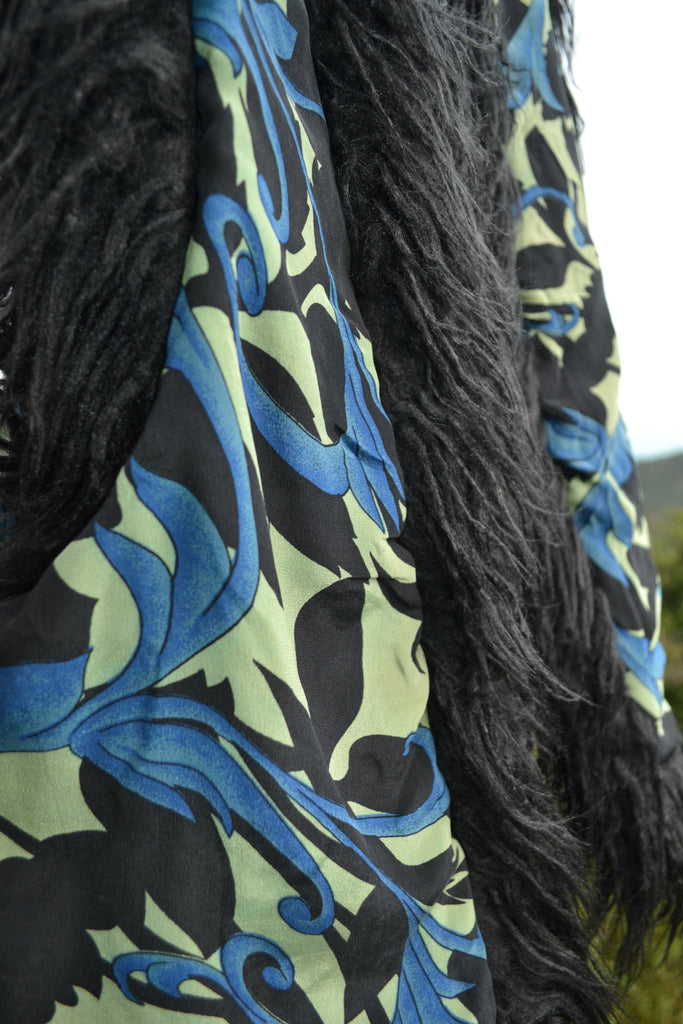 Detailed view of pink floral embroidery on the black cotton fabric of the Midnight Rose vest